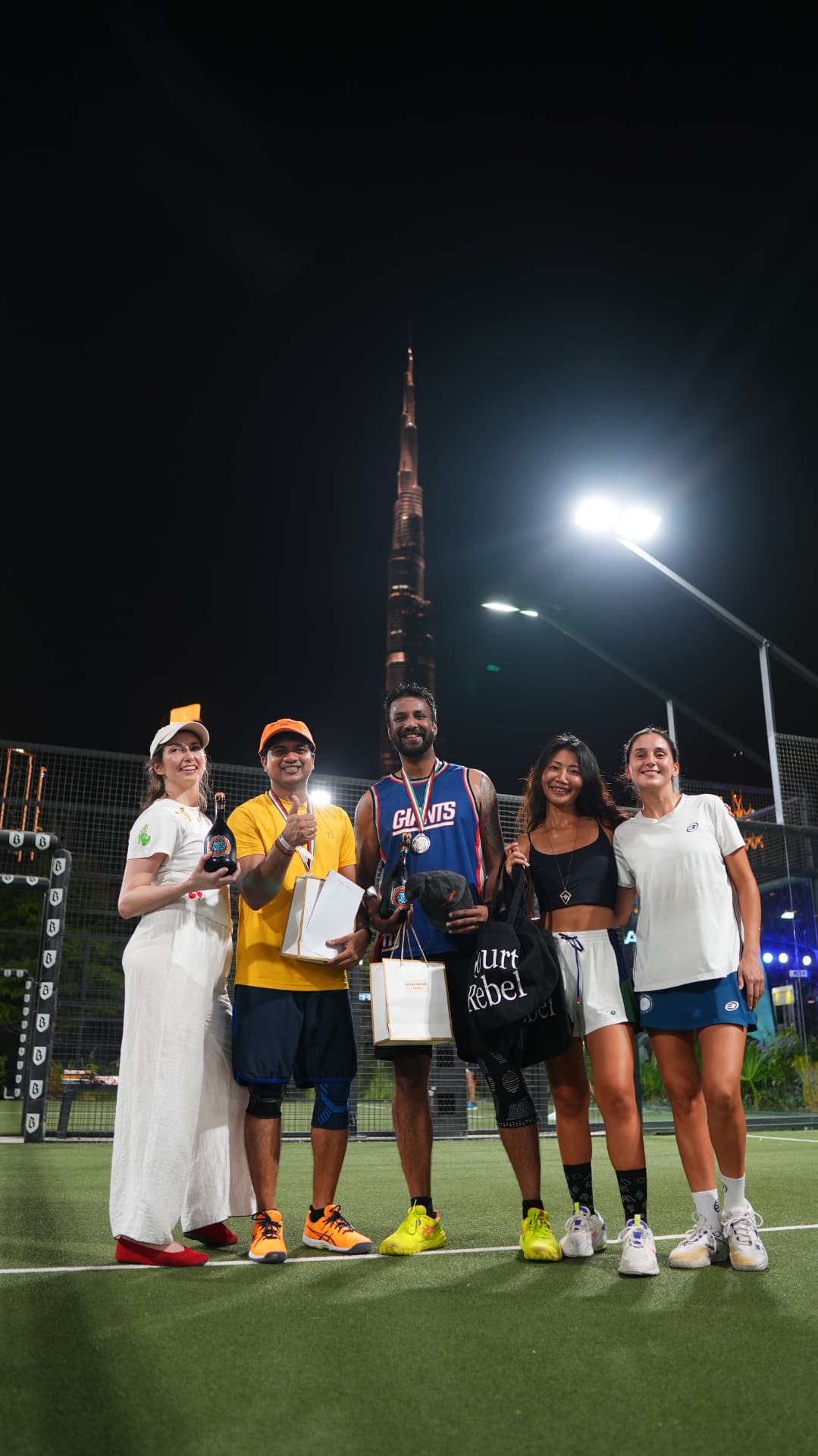Players posing with their awards on court at night