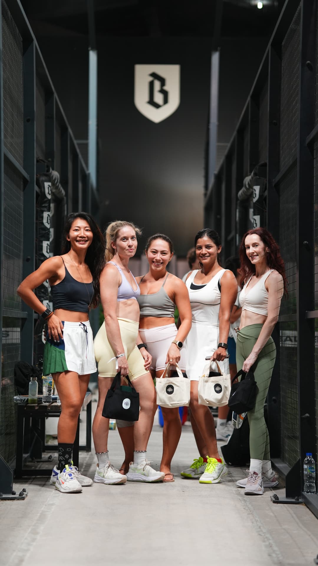 Five players posing together between the courts