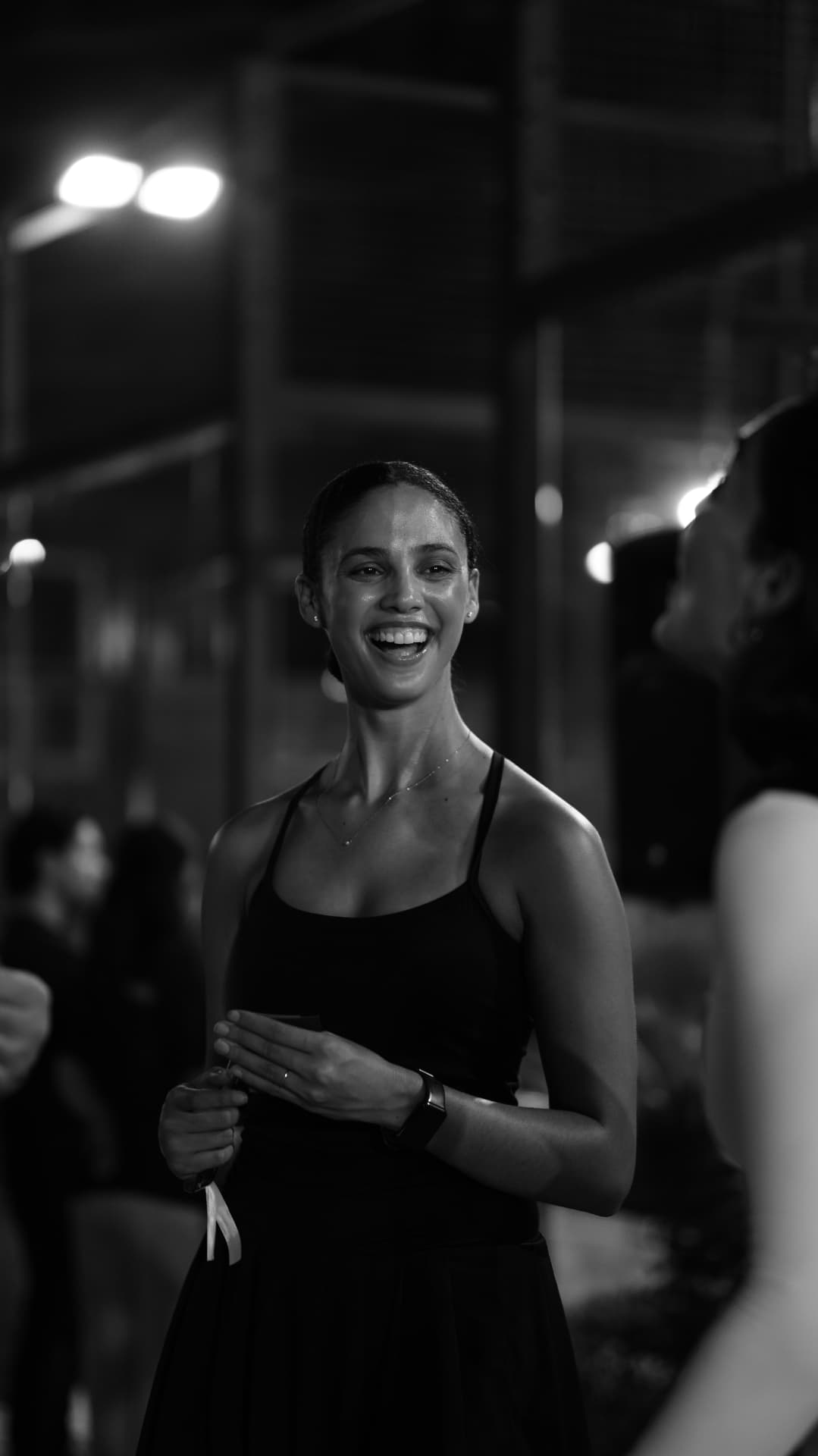 Guests talking and laughing under the court lights