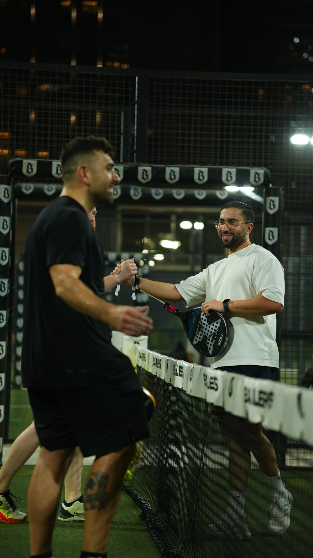 Two players shaking hands across the net after a match