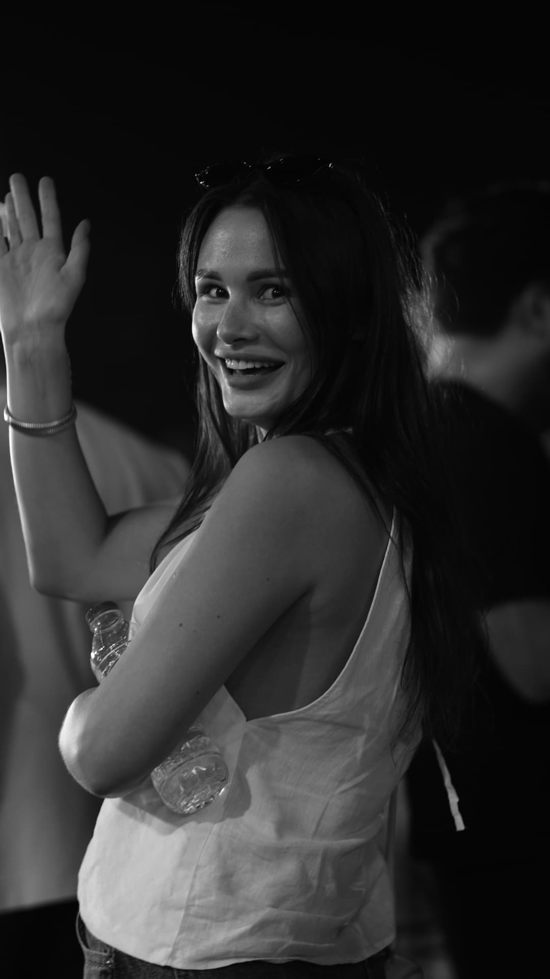 A guest turning and waving at an evening gathering